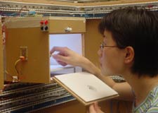 LRC graduate student Yimin Gu examines an LED array mounted inside an LED testing chamber.